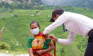 Vacunación de una mujer contra la COVID-19 en un puesto de salud del remoto distrito de Darchula, en Nepal.