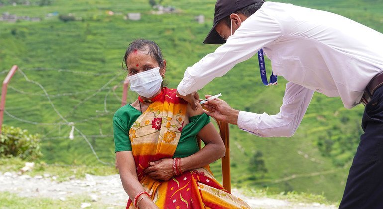 Vacunación de una mujer contra la COVID-19 en un puesto de salud del remoto distrito de Darchula, en Nepal.