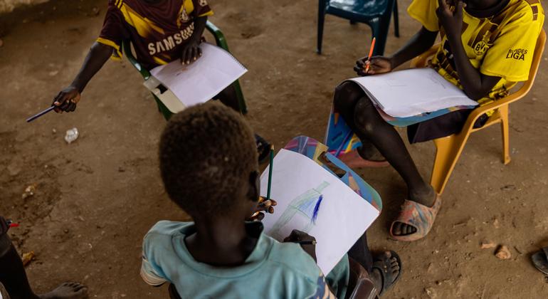 Niños dibujando en una espacio infantil apoyado por UNICEF en un campamento de desplazados en Darfur del Sur.