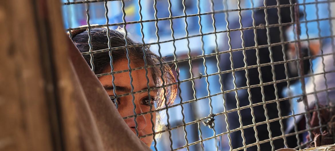 A young girl looks through a window in Khan Younis, Gaza.