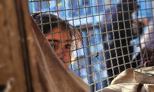 A young girl looks through a window in Khan Younis, Gaza.