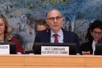 联合国人权事务高级专员福尔克·蒂尔克在日内瓦人权理事会讲话,他与其他官员,包括理事会主席和秘书一道,在一场巨大的抽象壁画面前,坐在一个小组的座席上。