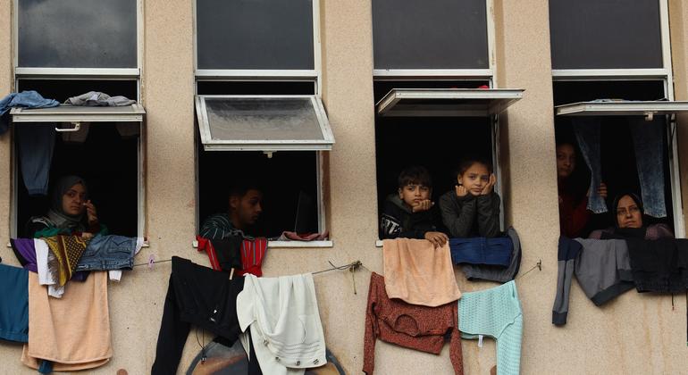 On 11 January 2024, internally displaced people look through the window at a shelter centre in Al-Quds Open University.