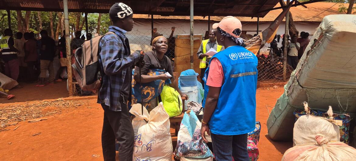 Buchumi Deuline, 58 ans, se tient à un centre de départ en Tanzanie, assistée par le personnel du HCR, dans le cadre du programme de rapatriement volontaire pour les réfugiés burundais.