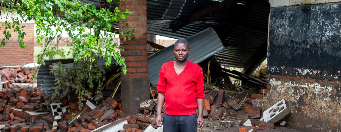 Un enseignant se tient devant une école endommagée lorsque le cyclone Freddy a frappé le Malawi.