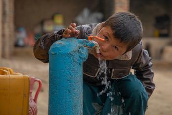 Um menino usa uma torneira de água recentemente instalada pela ONU na província de Faryab, no Afeganistão