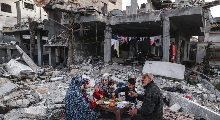 Uma família em Gaza faz uma refeição entre os escombros de sua casa.