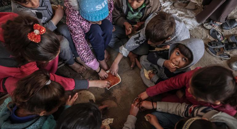 Los niños comparten una pequeña cantidad de comida proporcionada por el Programa Mundial de Alimentos de la ONU.