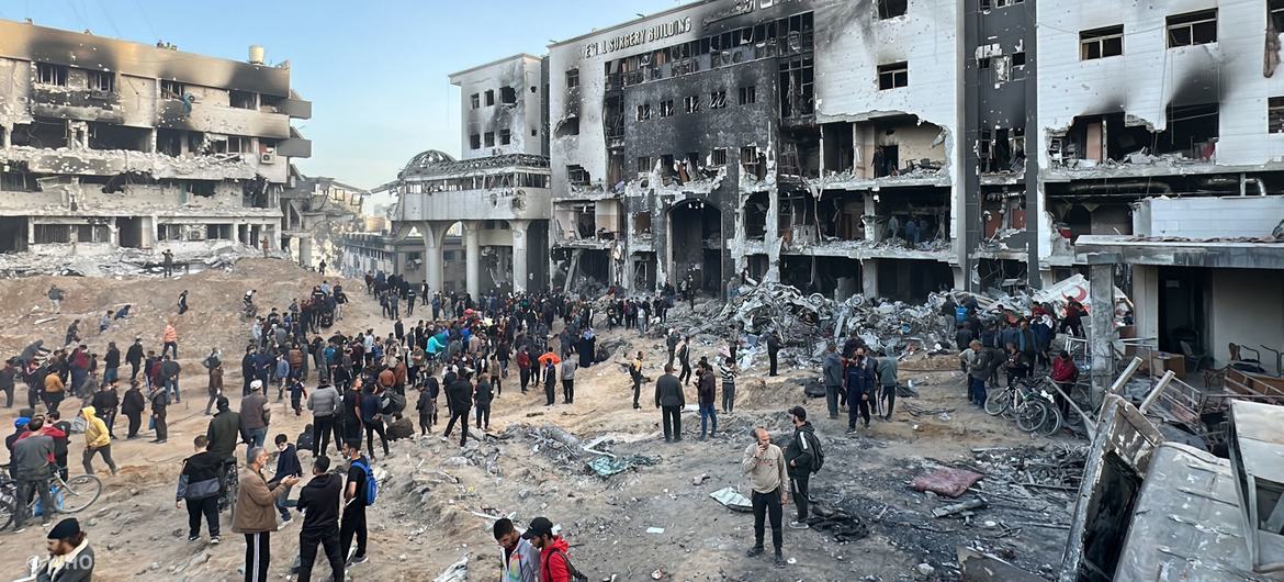 Des gens sont rassemblés devant les ruines de l'hôpital Al Shifa, le plus grand établissement de santé de Gaza.