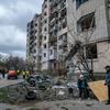 Un couple s'attarde devant un immeuble résidentiel bombardé à Kupiansk, dans la région de Kharkiv, en Ukraine.