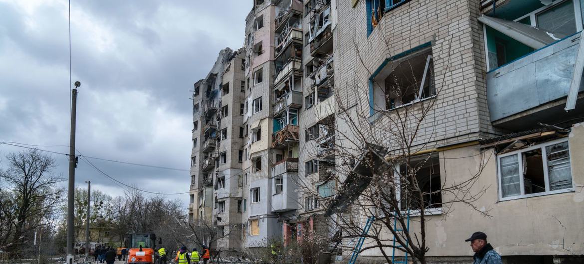 Un couple s'attarde devant un immeuble résidentiel bombardé à Kupiansk, dans la région de Kharkiv, en Ukraine.