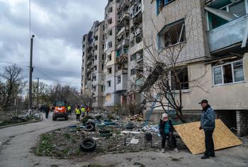 Un couple s'attarde devant un immeuble résidentiel bombardé à Kupiansk, dans la région de Kharkiv, en Ukraine.