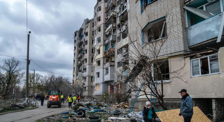 Un couple s'attarde devant un immeuble résidentiel bombardé à Kupiansk, dans la région de Kharkiv, en Ukraine.