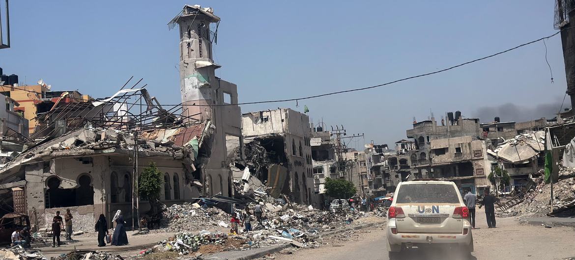 Un véhicule de l'ONU passe devant des bâtiments en ruines à Gaza City.