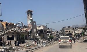 Un véhicule de l'ONU passe devant des bâtiments en ruines à Gaza City.