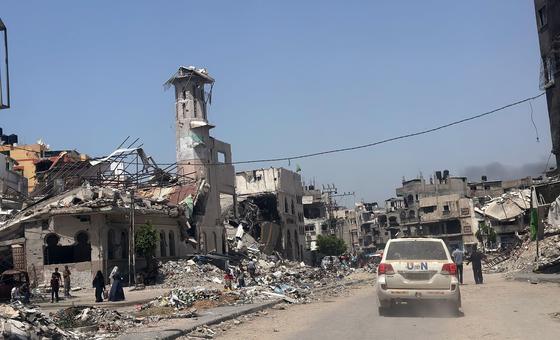 Un véhicule de l'ONU passe devant des bâtiments en ruines à Gaza City.