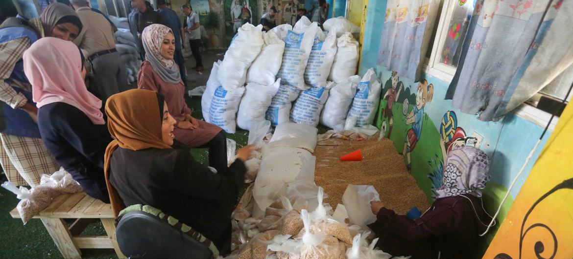 UNRWA staff distribute food to displaced families in Deir Al-Balah, Gaza. 