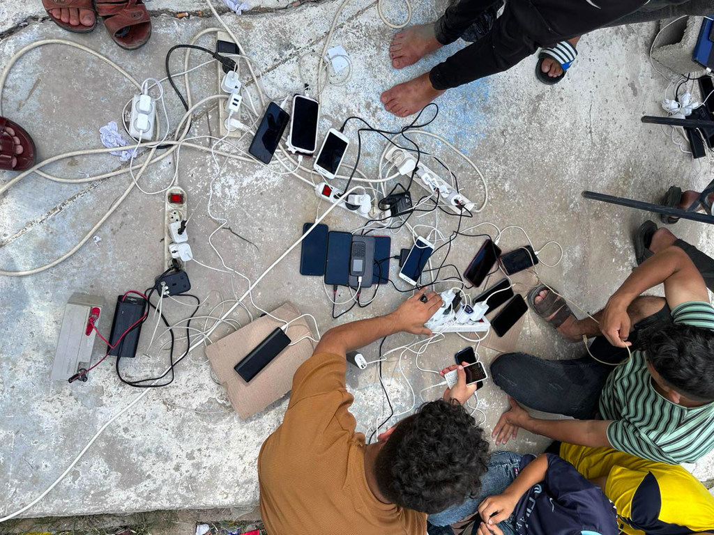 Las personas atrapadas en el conflicto de Gaza recargan sus teléfonos móviles.