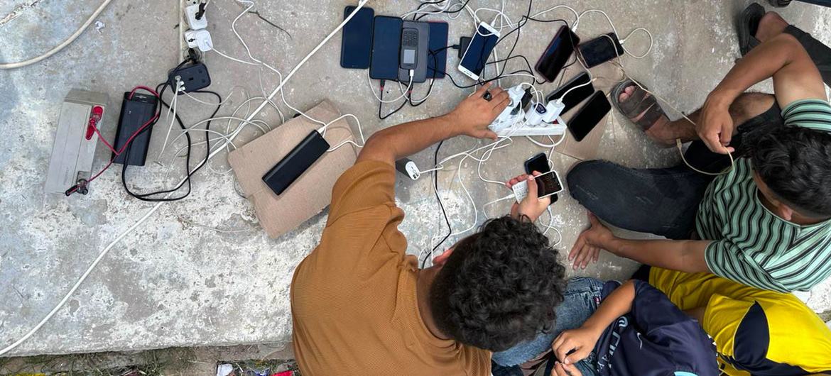 Las personas atrapadas en el conflicto de Gaza recargan sus teléfonos móviles.