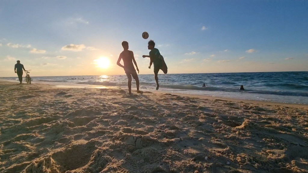 Two football players practice on a beach in Gaza.