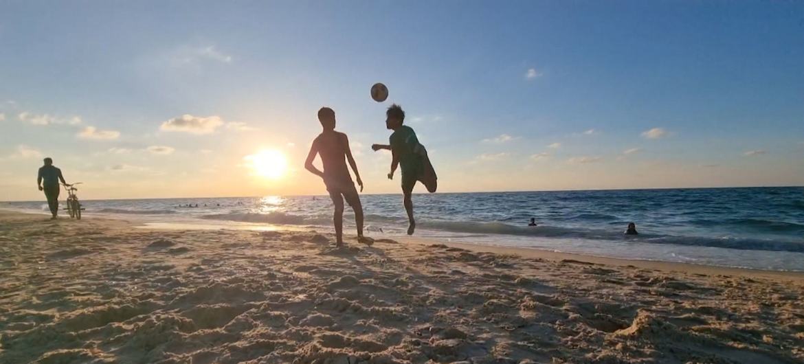 Two football players practice on a beach in Gaza.