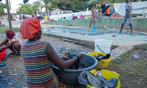 A woman displaced by violence in the Haitian capital, Port-au-Prince, washes clothes in a city park.