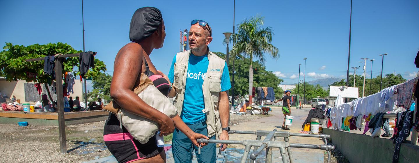 Un membre du personnel de l'UNICEF s'entretient avec un habitant du quartier de Cité Soleil à Port-au-Prince, la capitale d'Haïti.