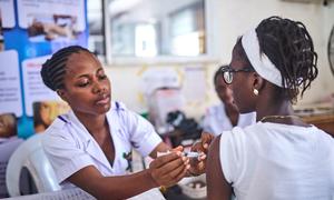 A health worker immunizes a girl with the HPV vaccine in Lagos, Nigeria, as part of Africa's largest vaccination campaign.
