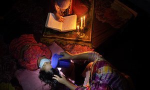 ढाका में ली गई इस तस्वीर में एक माँ को अपनी छोटी बेटी के बुखार को कम करने की कोशिश कर रही है, वहीं उसकी बड़ी बेटी कुरान पढ़ रही है. 