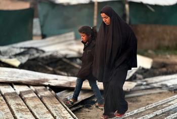 A woman and child walk through the rubble of Gaza.