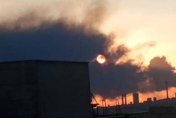 Sunset behind thick smoke rising over the Tehran city skyline in Iran.