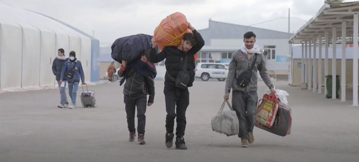 Refugiados afganos que llevan grandes bolsas y equipaje al regresar de Irán en medio de un conflicto creciente.