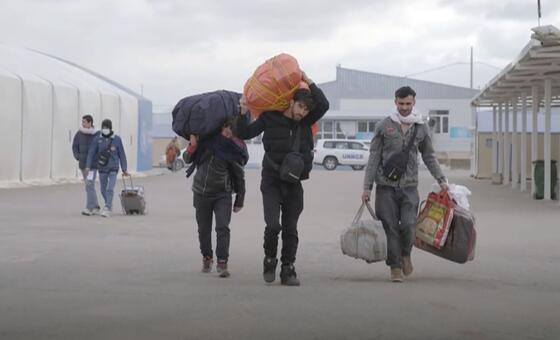 Афганцы, возвращающиеся из Ирана, прибывают на пограничный пункт.