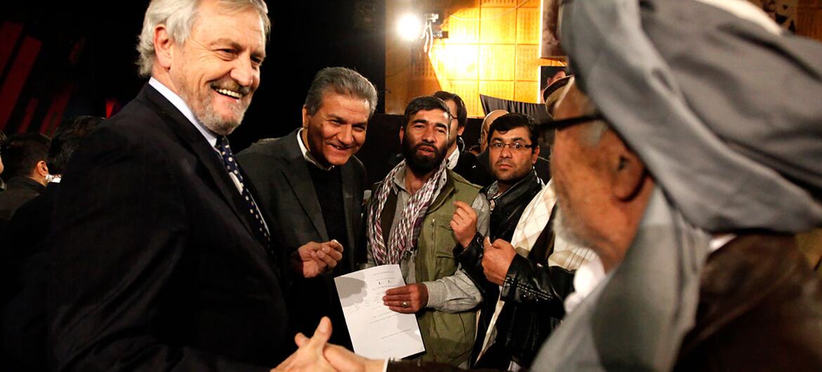 Nicholas Haysom, Special Representative of the Secretary-General and Head of UNAMA, smiles while shaking hands with an audience member during a debate broadcast on the state television program Open Jirga.