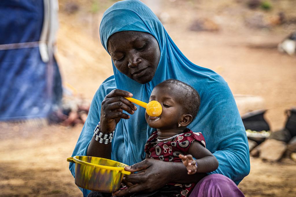 Une mère donne de la bouillie à sa fille de 10 mois au Burkina Faso, dans la région du Sahel, où le PAM fournit une assistance pour prévenir la malnutrition.