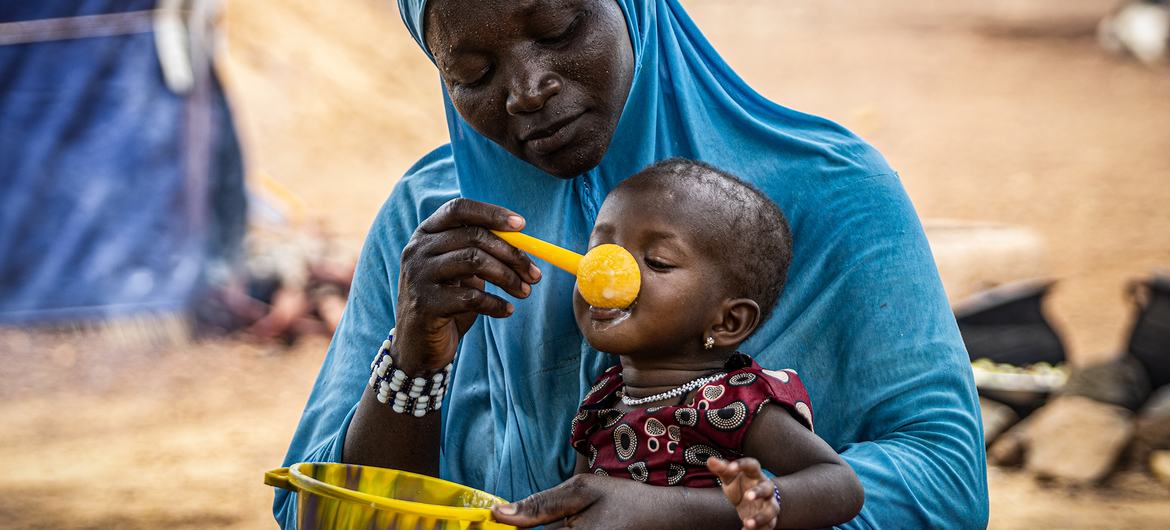 Una madre da papilla a su hija de 10 meses en Burkina Faso, en la región del Sahel, donde el PMA presta asistencia para prevenir la malnutrición.