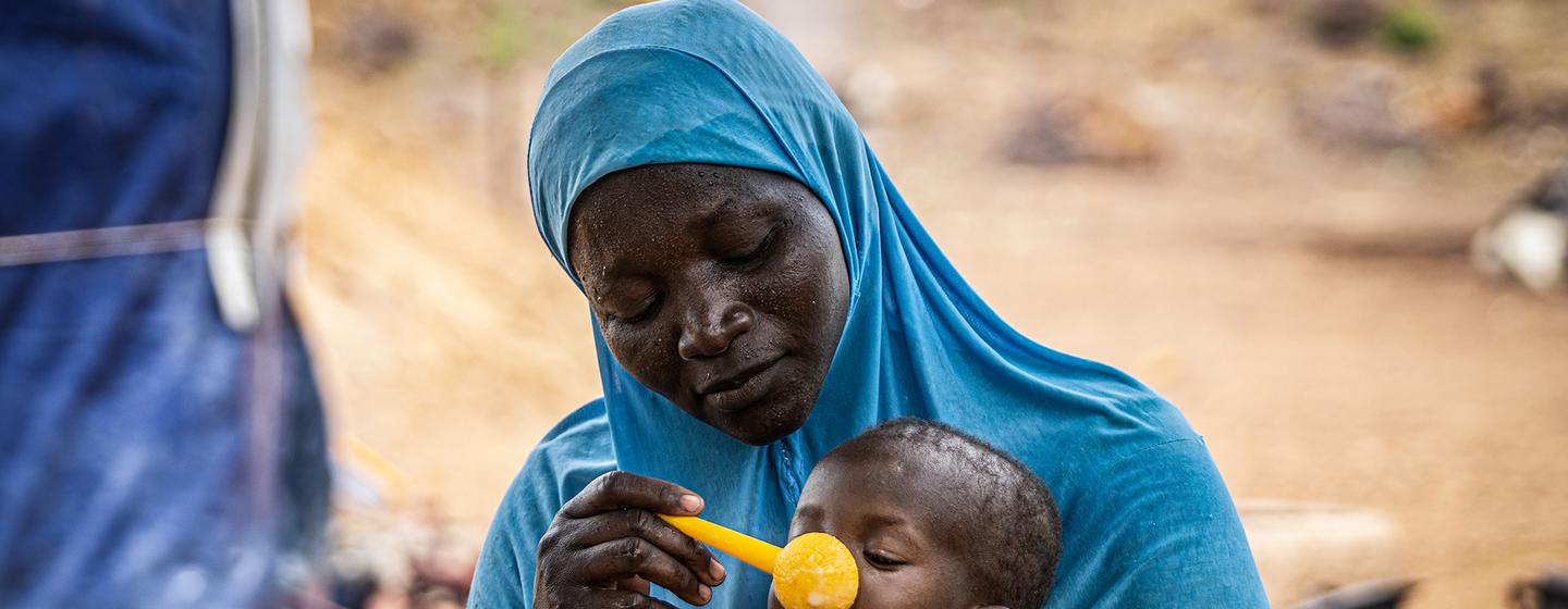 Une mère donne de la bouillie à sa fille de 10 mois au Burkina Faso, dans la région du Sahel, où le PAM fournit une assistance pour prévenir la malnutrition.