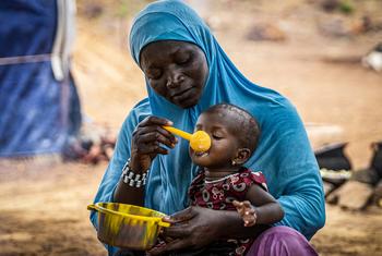 A mother gives her 10-month-old daughter porridge in Burkina Faso in the Sahel region, where WFP is providing assistance to prevent malnutrition.