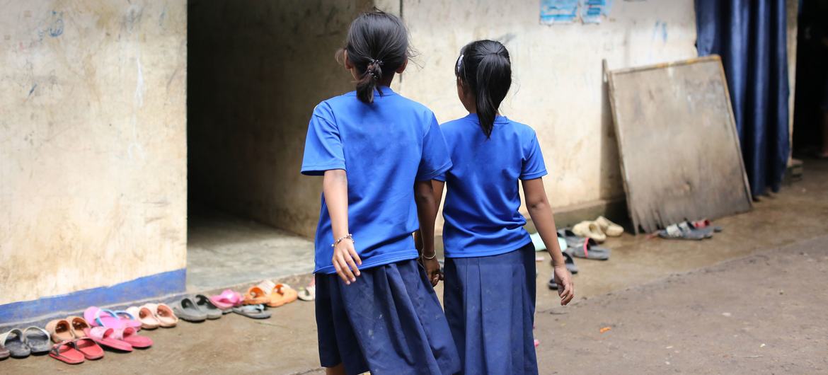 Two girls return to class at a migrant learning centre.