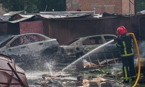 In Poltava, a city in central Ukraine, emergency service personnel work to douse debris left smoldering after an attack.