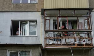 Men work at an apartment building in Poltava, a city in central Ukraine,  that was damaged in an attack.