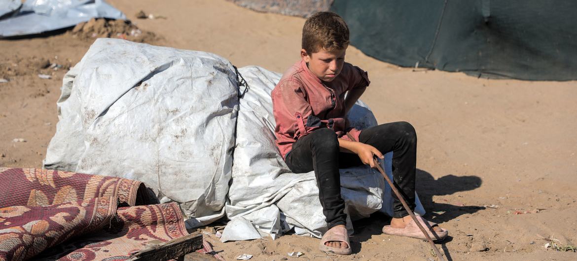 Un garçon est assis sur une pile de biens alors que sa famille se prépare à évacuer le nord de Gaza (photo d'archives).