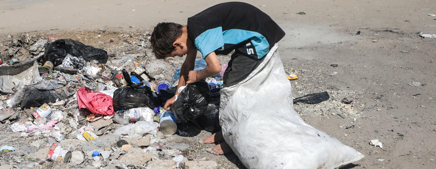 Dans le nord de Gaza, un garçon déplacé récupère du plastique et des débris dans un tas d'ordures pour les vendre comme combustible.