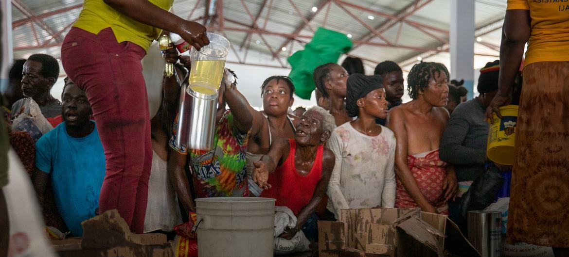 海地太子港一个受帮派影响地区的居民正在接受世界粮食计划署的粮食援助。