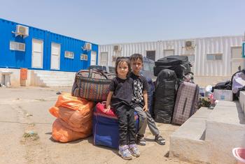 Watoto wawili wadogo wameketi karibu na mali ya familia yao kwenye kivuko cha mpaka cha Islam-Qala, saa chache baada ya kurejea Afghanistan.