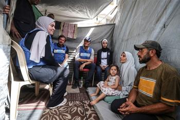 اقوام متحدہ کا عملہ غزہ میں ایک فلسطینی خاندان سے ملاقات کر رہا ہے۔