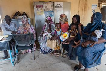 Mothers and caregivers with young children wait in a clinic in Sudan for outpatient nutrition services provided by UNICEF.