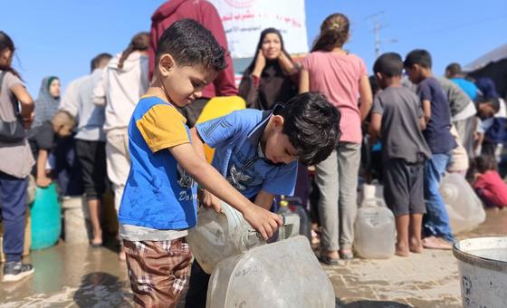 Young boys fill water containers in Gaza.
