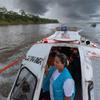 Gissela Vásquez, técnica de enfermería y trabajadora de enlace comunitario, mira desde la puerta de una embarcación que navega por el río Tigre en Loreto, Perú.