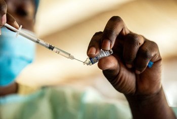 أحد العاملين الصحيين في أنغولا يقدم لقاحا ضد كوفيد-19.